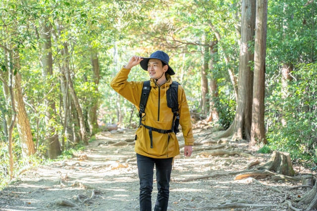 Ilustrasi orang Jepang memakai jaket dan topi sedang naik gunung.