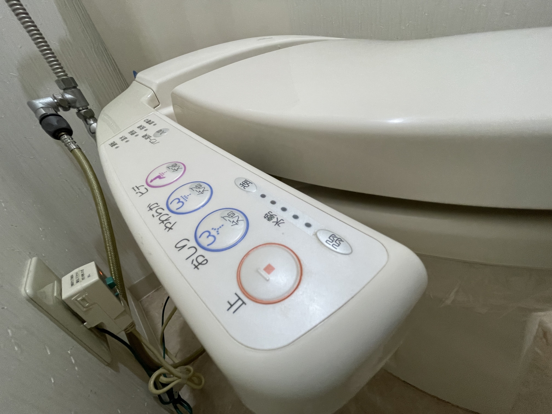 Tombol toilet canggih di Jepang di bagian samping. Lengkap dengan gambar, Bahasa Inggris, dan Bahasa Jepang.