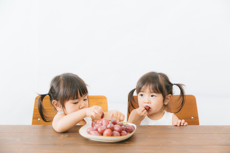 Anak-anak sedang makan buah.