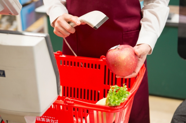 Kasir supermarket memindai belanjaan pelanggan.