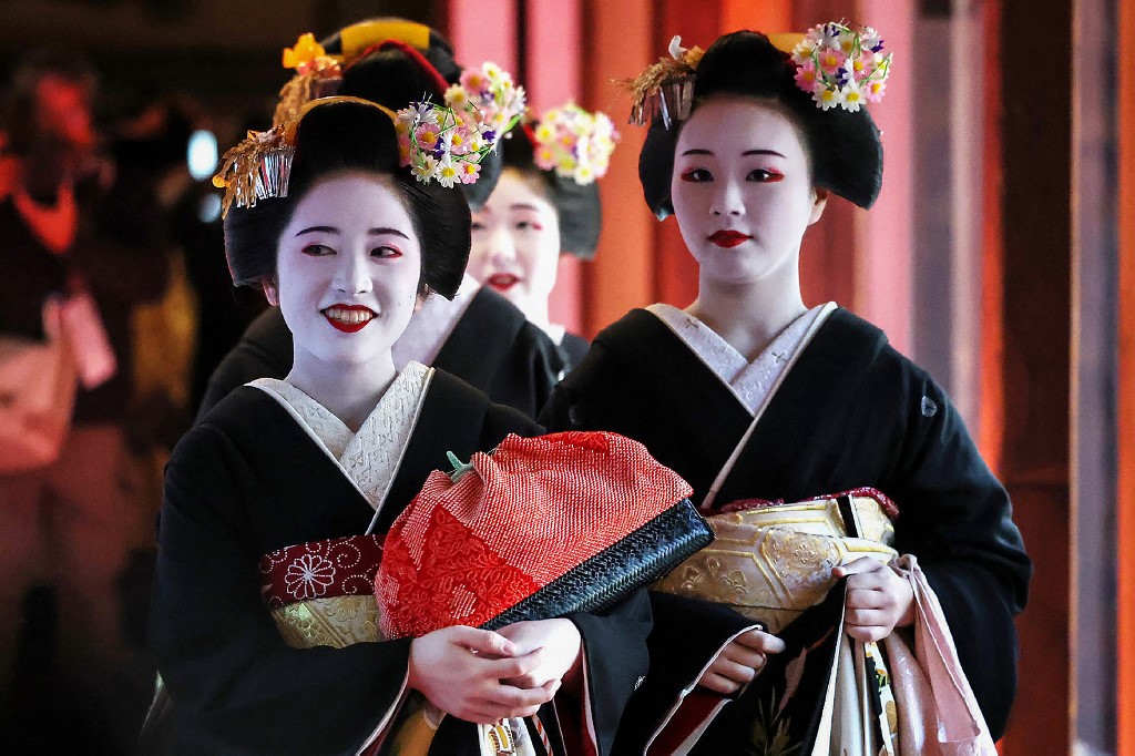 Geisha dan maiko (calon geisha) memakai kostum formal tradisional dengan jambul hitam dan jepit rambut yang terbuat dari beras. Mereka menghadiri upacara pembukaan di sebuah tempat untuk bertukar ucapan selamat Tahun Baru, di distrik hiburan Gion di Kyoto pada 7 Januari 2025.