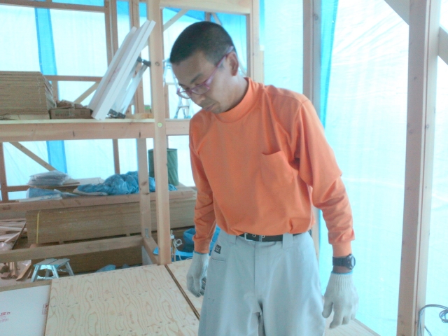 Seorang pria mengenakan outfit blus lengan panjang dengan celana bahan katun.