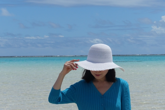 Seorang wanita dengan outfit cardigan dengan memakai topi.