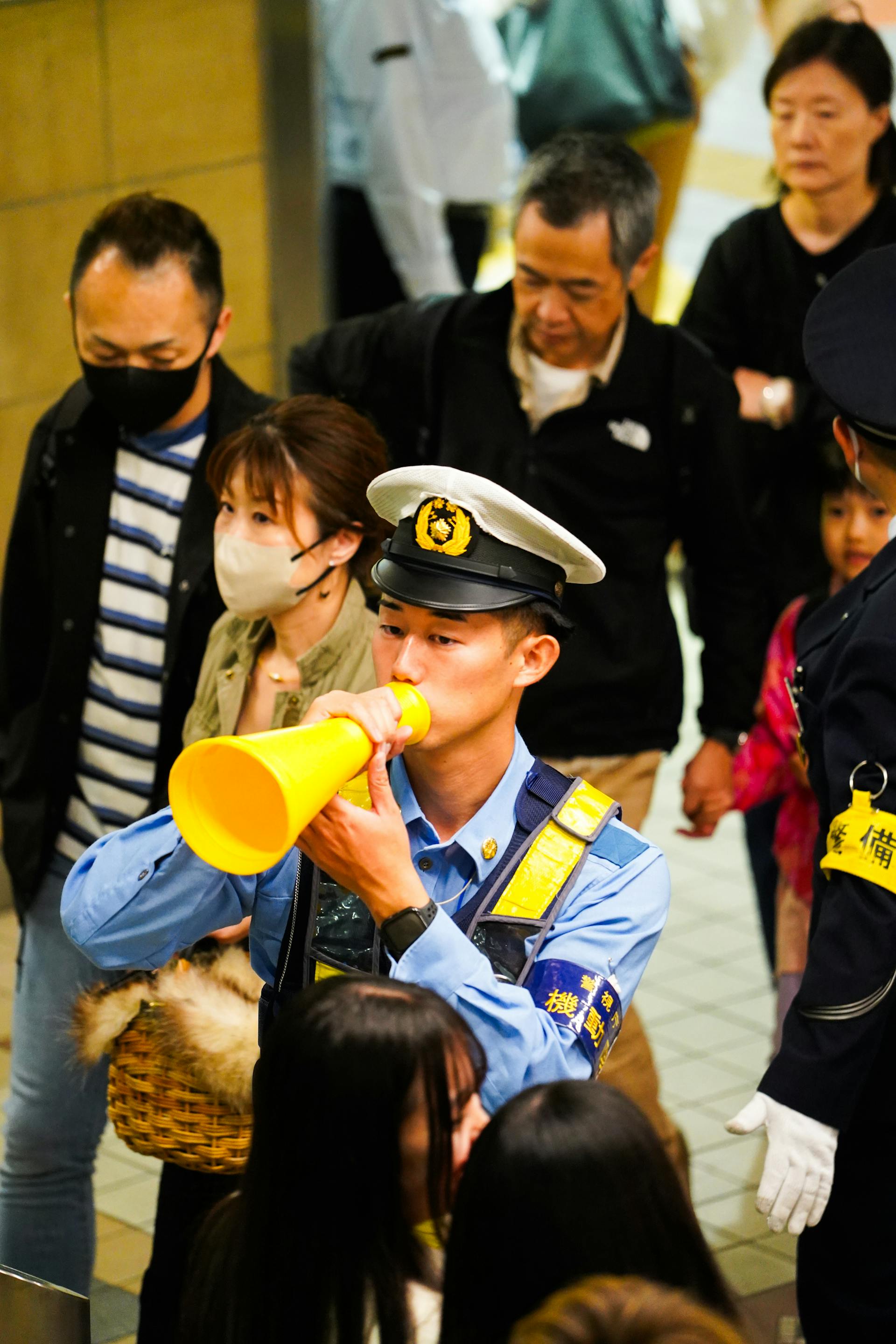 Polisi Jepang memandu kerumunan di kereta bawah tanah Tokyo.