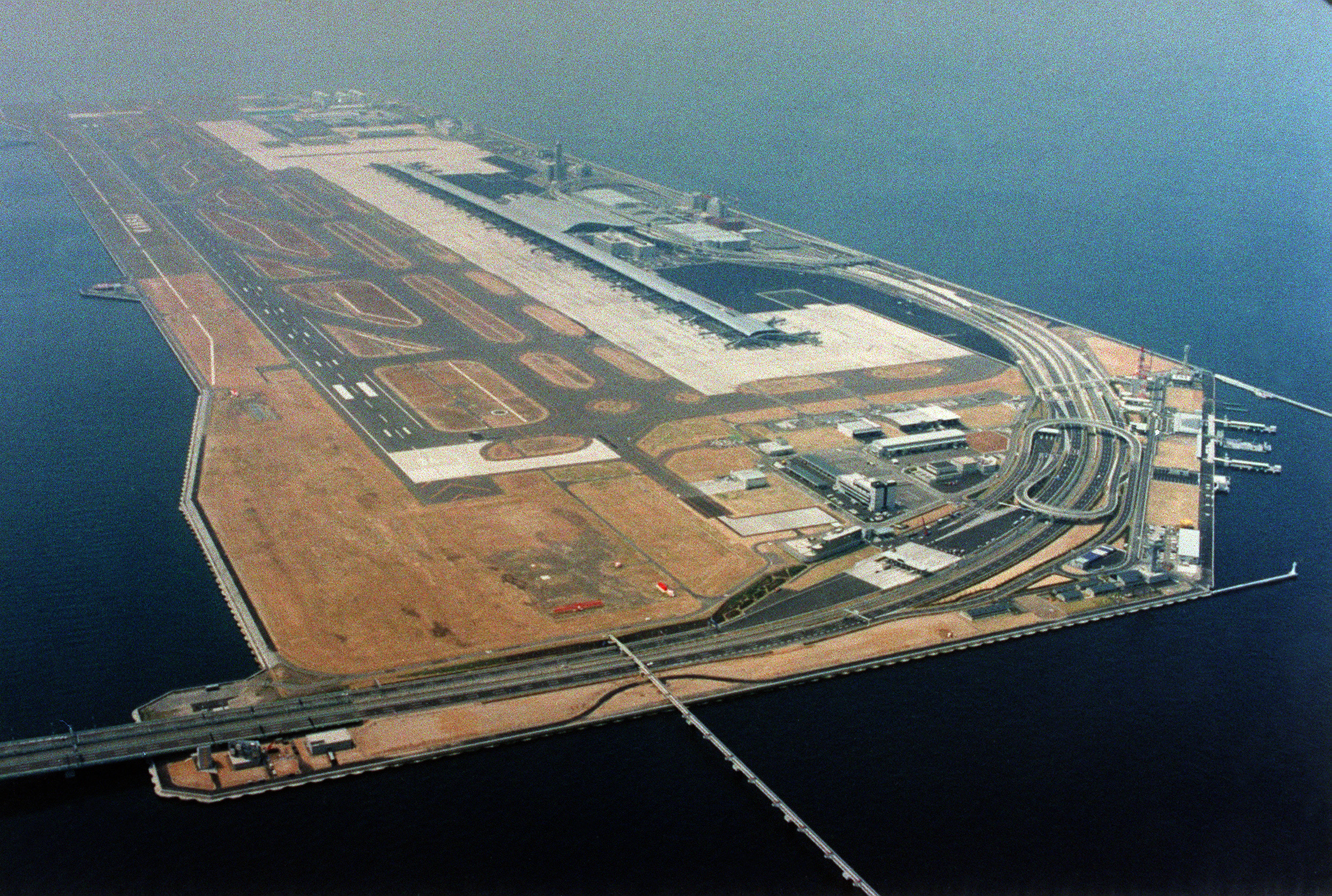 Bandara Internasional Kansai di Jepang yang dibangun di atas pulau buatan seluas 511 hektare di Teluk Osaka, sekitar lima kilometer dari pantai. Permukaan tanah Bandara Kansai terus menurun sejak dibangun. (Foto diambil pada 1994)