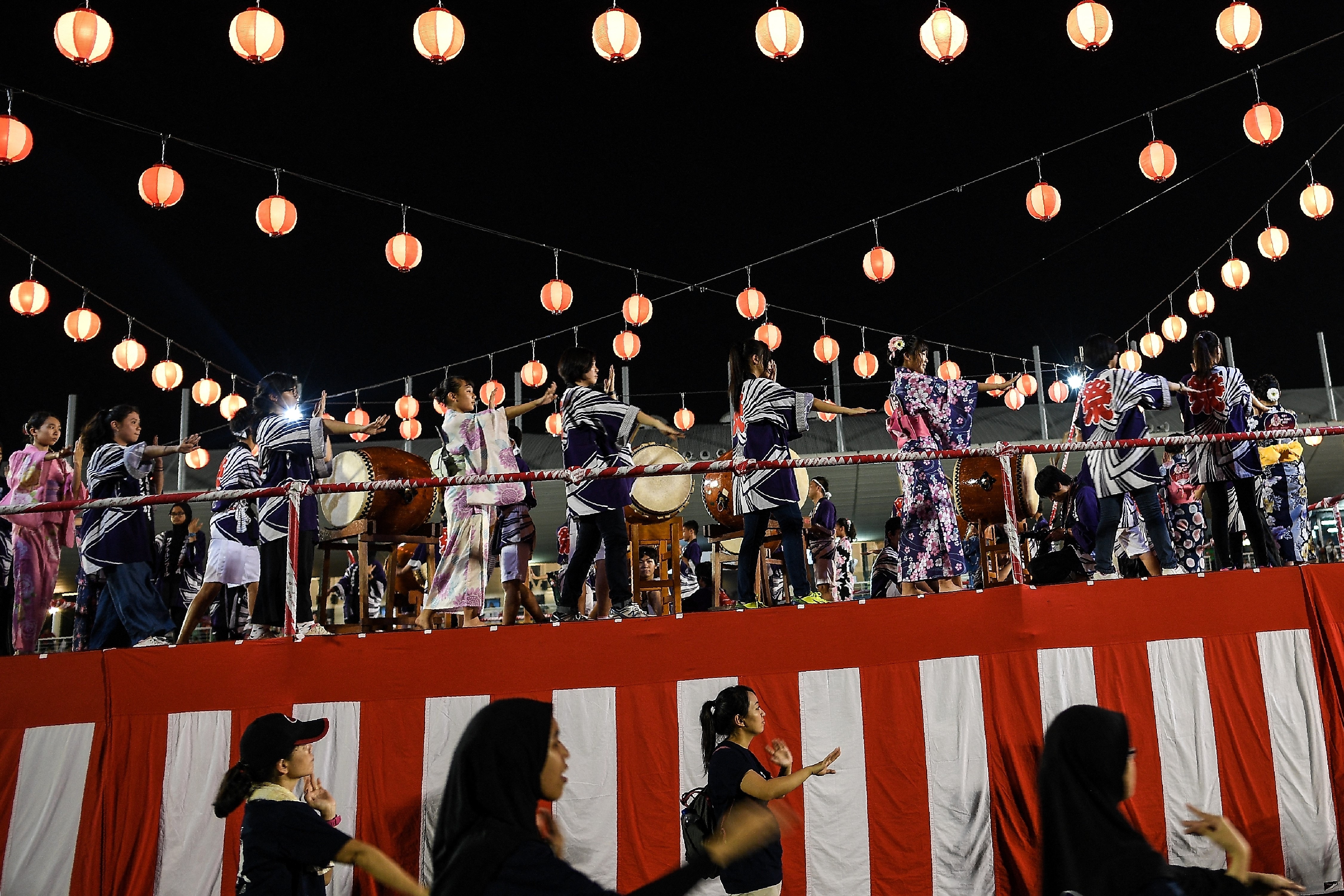 Penari mengelilingi panggung untuk menari dalam festival Obon di Jepang.