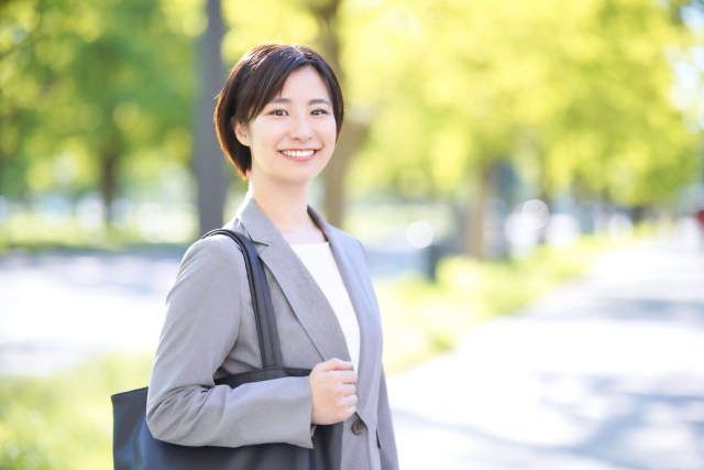 Seorang wanita mengenakan outfit blus dan blazer.