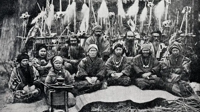 Potret masyrakat Ainu di Hokkaido, di depan sebuah gubuk yang mereka persembahkan kepada dewa-dewa yang melindungi desa. Foto diambil dari Journal des Voyages, tahun 1909.