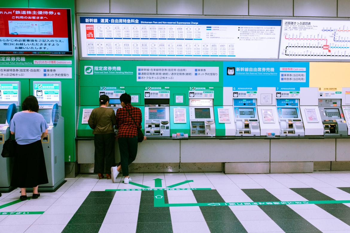 Dua orang yang sedang membeli tiket di stasiun kereta.