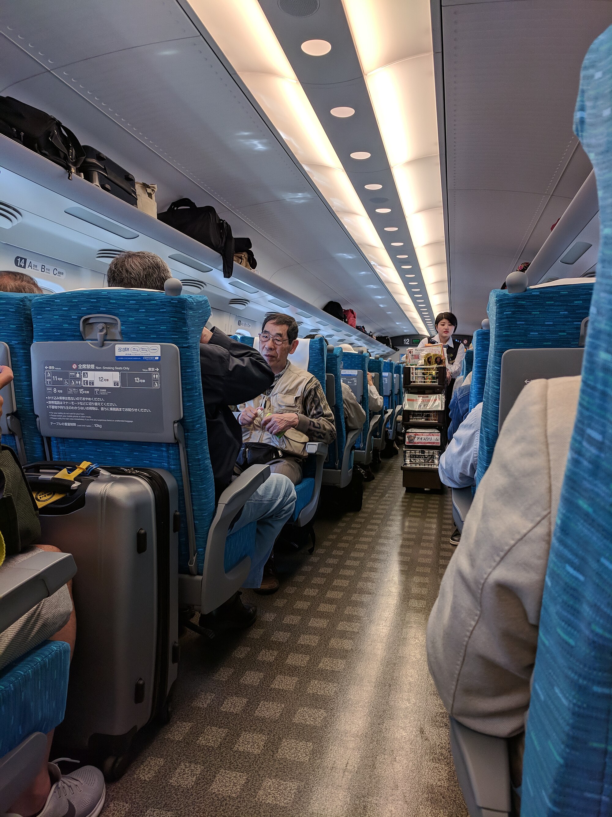 Seorang pramugari mendorong gerobak makanan ringan di lorong kereta Shinkansen selama perjalanan di dekat Odawara.