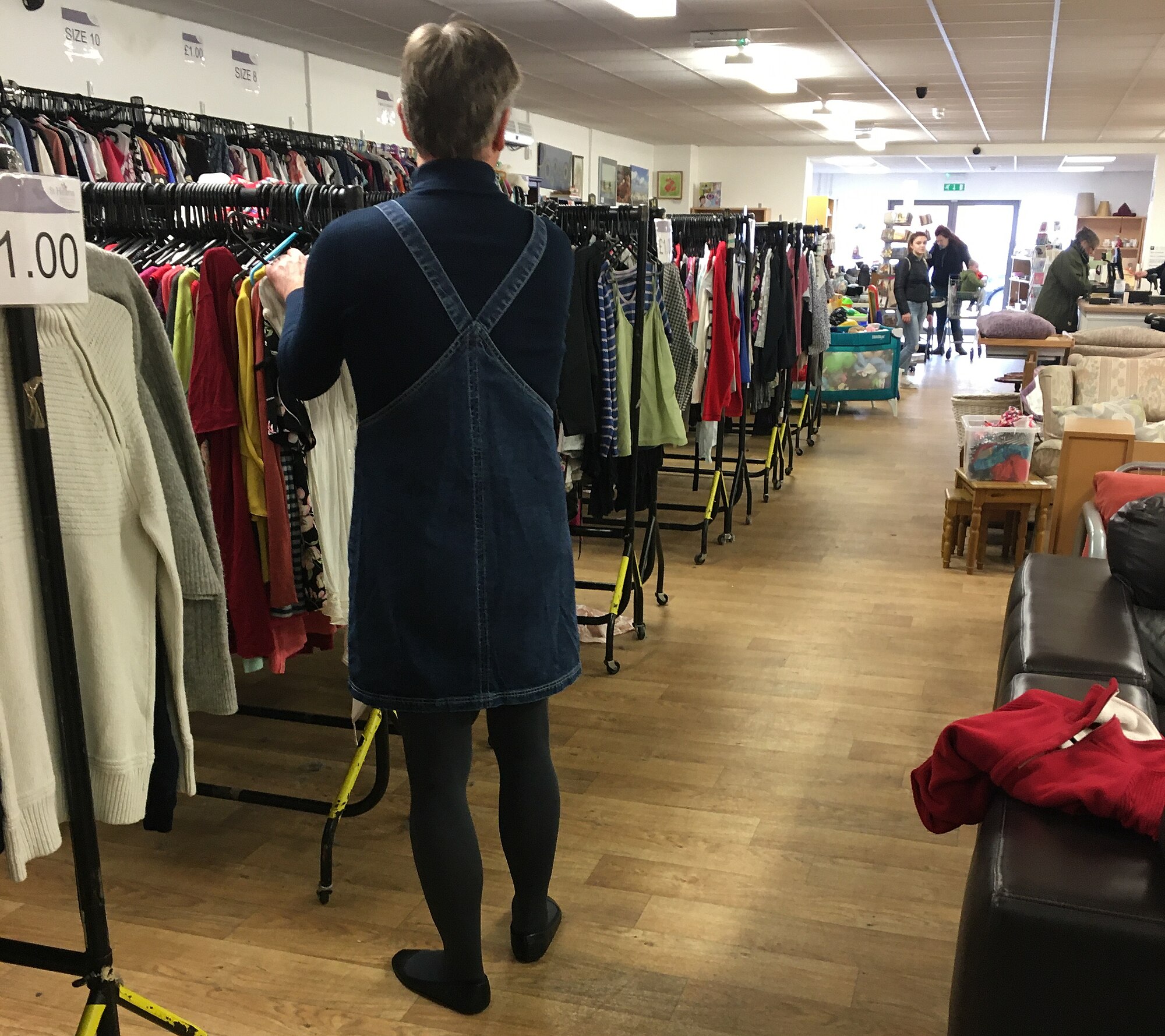 Gaun denim berkerah, sweater bergaris biru navy, kaus kaki tebal abu-abu 100 denier, dan sepatu balet yang dikenakan saat bekerja di toko.
