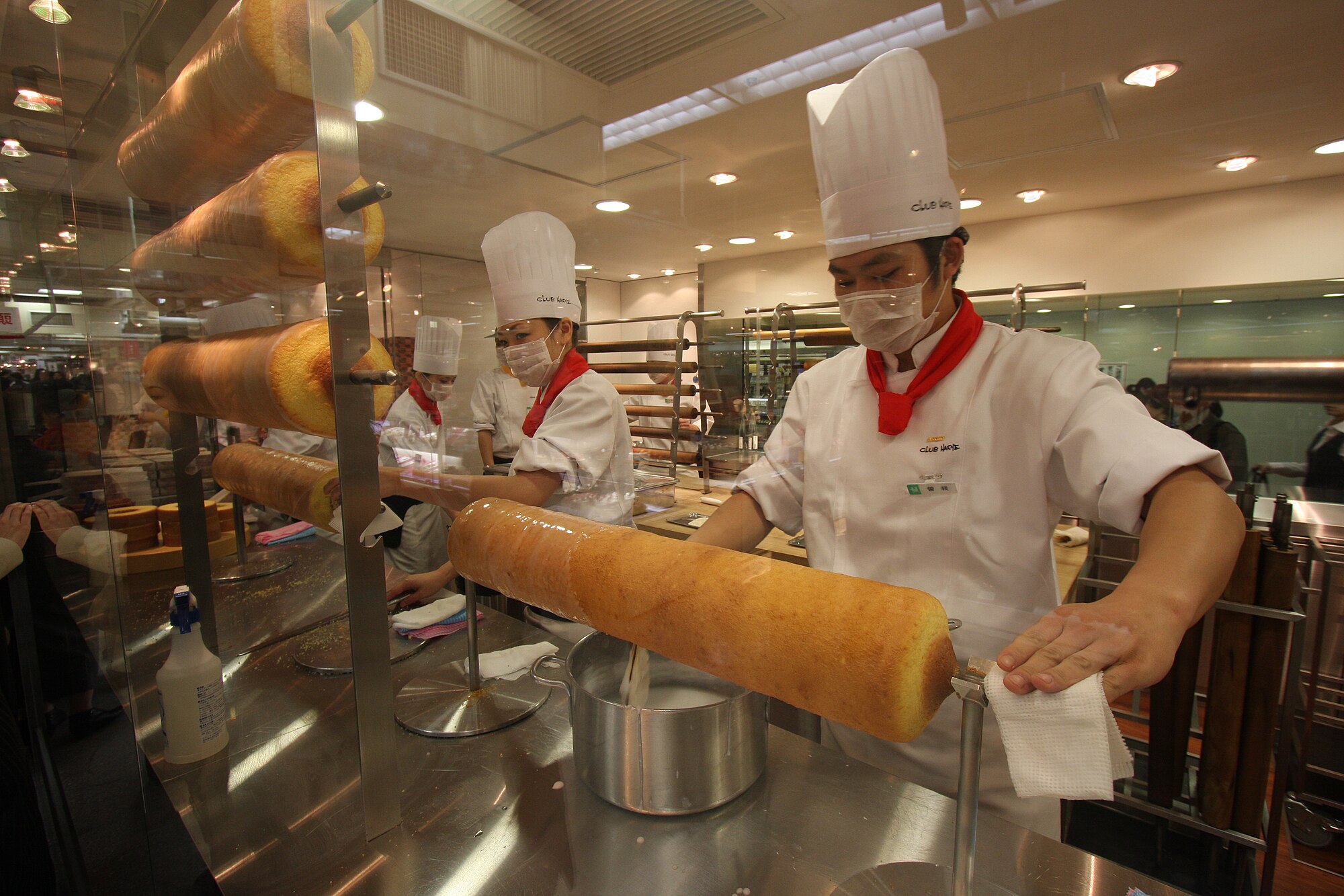 Beberapa orang yang sedang membuat Baumkuchen di toko Departemen Hanshin, Stasiun Osaka, Jepang.