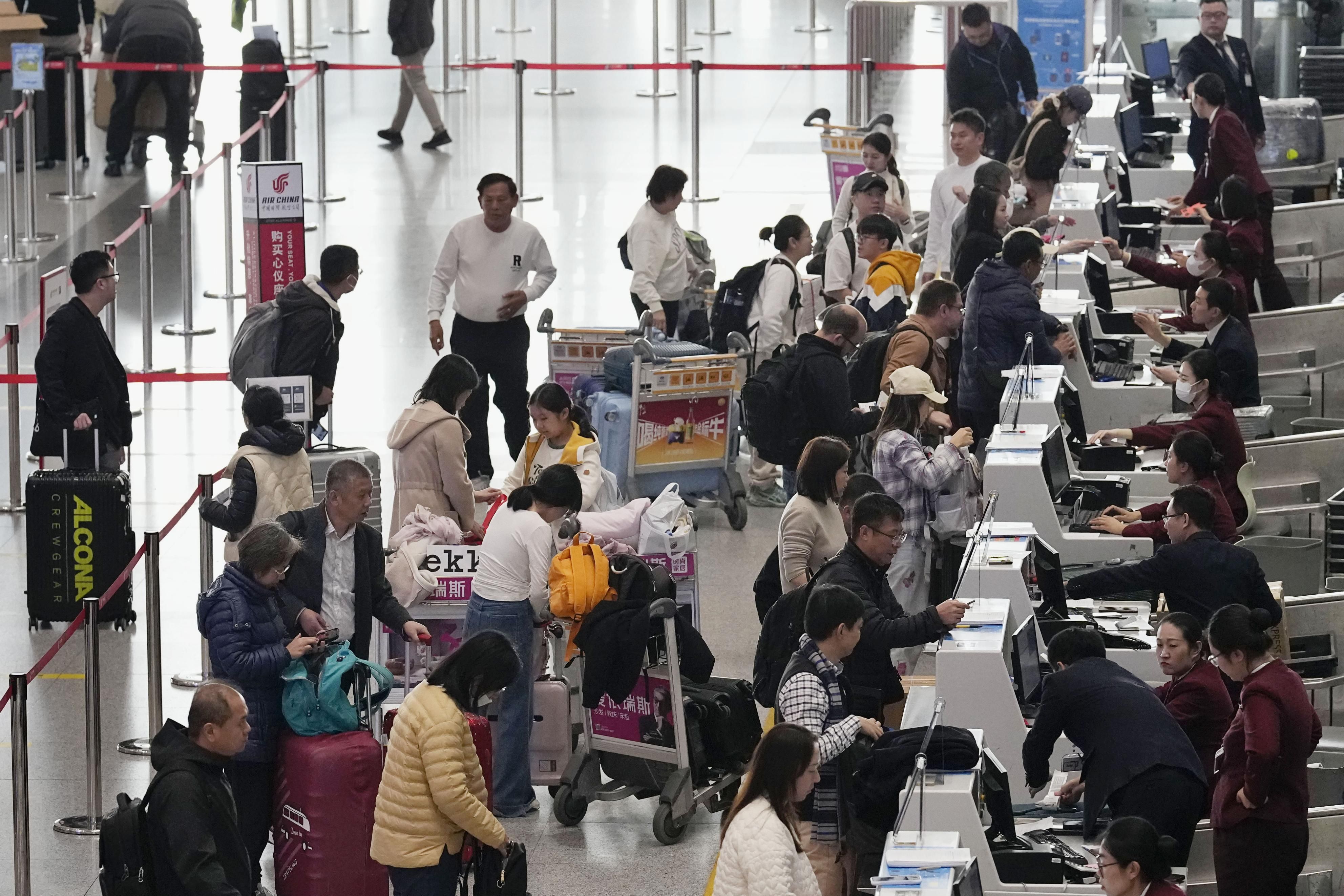 Orang-orang check-in untuk penerbangan mereka, termasuk yang menuju Jepang, di Bandara Internasional Ibu Kota Beijing di Tiongkok pada 15 November 2025.