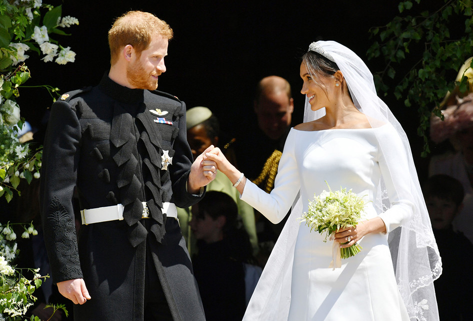 Pangeran Harry dan Meghan Markle meninggalkan Kapel St George di Kastil Windsor setelah pemberkatan pernikahan di Windsor, Inggris, Sabtu (19/5/2018). Sebanyak 600 tamu undangan menghadiri jamuan makan siang dan makan malam pada acara resepsi, ditambah 2.640 tamu dari warga biasa yang akan menimati teh dan kudapan di Istana Windsor.. (AFP PHOTO/POOL/BEN BIRCHALL)