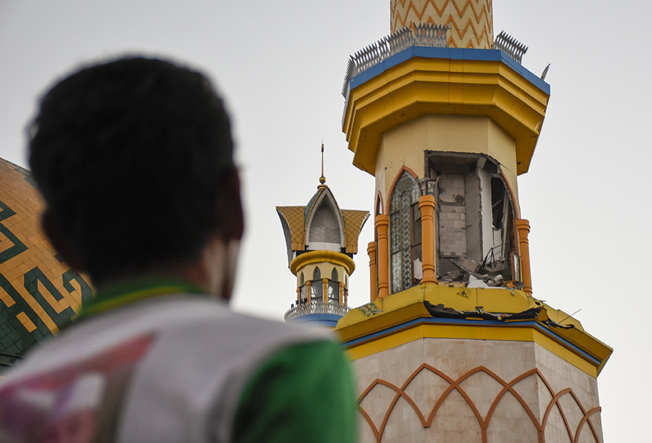 Seorang laki-laki mengamati menara Islamic Center Hubbul Wathan yang dindingnya sebagian roboh pascagempa bumi di Mataram, NTB, Senin (6/8/2018).