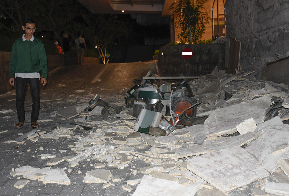 Seorang warga melintasi runtuhan tembok papan nama Hotel Santika akibat gempa bumi berkekuatan 7 skala richter (SR) di Mataram, NTB, Minggu (5/8/2018).