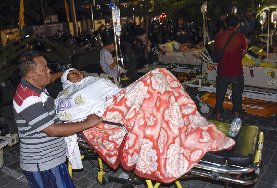 Suadah (41), korban gempa bumi berkekuatan 7 skala richter (SR) menjalani perawatan di halaman Rumah Sakit Kota Mataram, Minggu (5/8/2018).