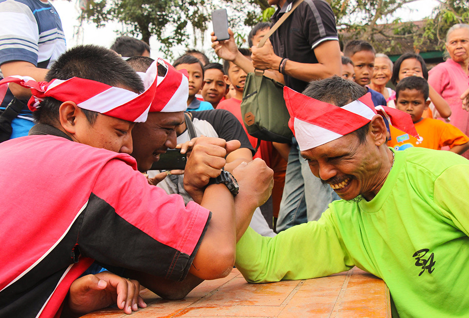 Sumanto melawan dua orang sekaligus dalam lomba adu panco.
